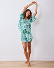 Load image into Gallery viewer, woman in the Printfresh Gator Grove Eco Satin Sweet Dreams Set in Blue Lagoon short sleeve button down top and short shorts
