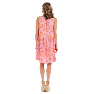 woman in a orange and pink floral dress photographed from the backl