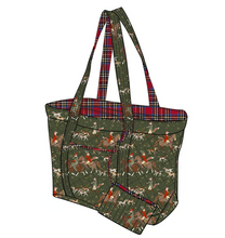 Load image into Gallery viewer, A tote bag with a green camouflage-style print featuring deer and red accents, with red, blue, and yellow plaid patterned handles and lining, shown on a plain white background.
