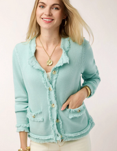 Load image into Gallery viewer, A woman wearing a light mint green fringed cardigan with gold buttons, styled with a white top and cream pants against a plain light background.
