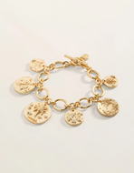 A gold charm bracelet featuring multiple round, textured coin-style pendants with tropical designs, displayed on a clean white background.