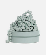 Load image into Gallery viewer, Stack of light blue pebbles inside a matching container on a white background
