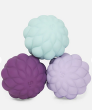 Load image into Gallery viewer, Three textured silicone balls in purple, green, and lavender on a white background
