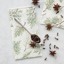 Load image into Gallery viewer, Hester &amp; Cook Juniper Sprigs Paper Napkins used with a spoon of clove
