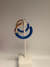 Load image into Gallery viewer, Pair of hoop earrings with blue and gold colors on a white stick against a gray background
