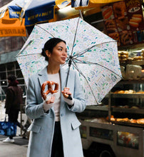 Load image into Gallery viewer, person using the Rifle Paper Camont Umbrella in a open air market  
