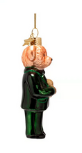 Load image into Gallery viewer, A Christmas ornament shaped like a teddy bear dressed in a shiny dark green suit, with a peach-colored face and hands, hanging from a gold string against a plain white background.
