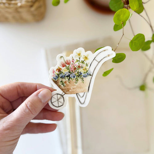 hand holding a Wheelbarrow filled with flowers Sticker in a watercolor style
