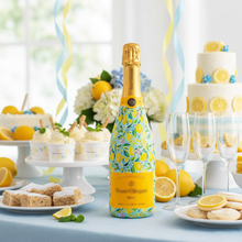 Load image into Gallery viewer, Champagne Bottle covered with the Preppy Lemons Champagne Bottle Wrap on a table set for a summer party
