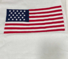 Load image into Gallery viewer, Close up of white long sleeve sweater with American flag
