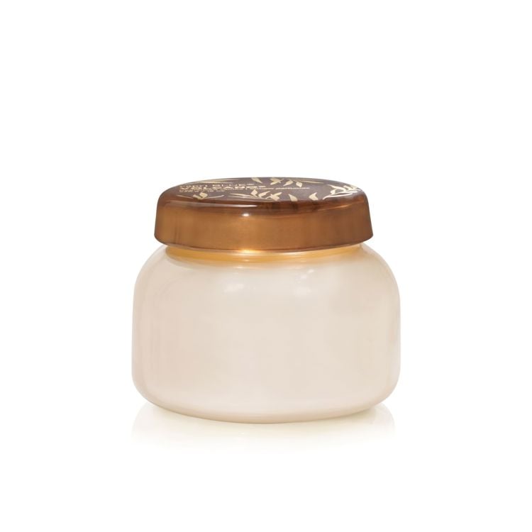 cream colored jar with bronze lid