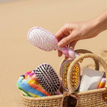 Load image into Gallery viewer, person putting the TELETIES Mini Detangler Brush into a basket with other brushes
