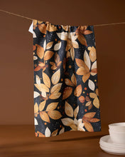 Load image into Gallery viewer, Geometry Botanical Wonderland Tea Towel handing from twine with a stack of clean dishes next to it
