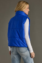 Load image into Gallery viewer, woman in a puffy Classic royal blue Vest paired with a black shirt and jeans back view 
