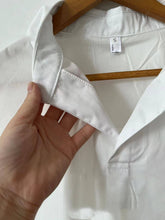 Load image into Gallery viewer, White Relaxed Short Sleeve Blouse on a hanger close up of neckline 
