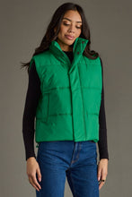 Load image into Gallery viewer, woman in a puffy Classic Green Vest paired with a black shirt and jeans with the vest closed
