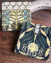Load image into Gallery viewer, two coaster one with a sea/fish and shell motif the other with a yellw blue and white floral motif 
