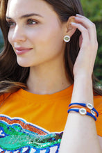 Load image into Gallery viewer, Person wearing blue and orange silicone bracelet with gator logo charms
