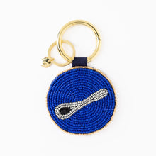 Load image into Gallery viewer, round beaded coin purse set on a gold hoop with a keyring. beads form the word a gray caviar spoon on a blue background

