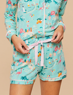 person in Pajama Shorts and top with a Florida print holding the pink tie at the waistband 