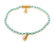 Twinkle Stretch Bracelet Sea Foam/Shell light blue stones intersperse with darker blue stones. two gold accents decorate the bracelet, one barrel shaped bead and one shell shaped bead, 
